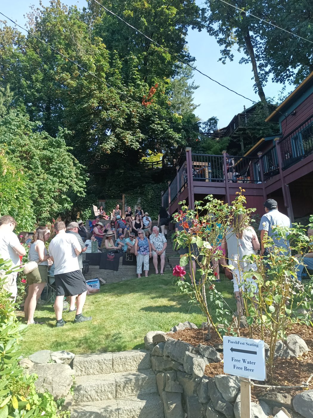 A packed front yard of festival goers enjoying live music